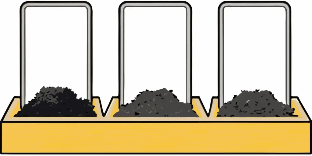 Three piles of black dirt, compost, and garden soil side by side on wooden surface for comparison